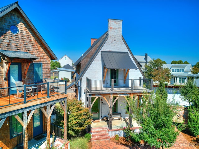 rear view of house with a patio area and a balcony