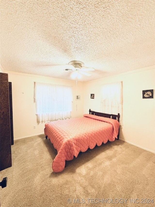 bedroom with crown molding, carpet floors, and a textured ceiling