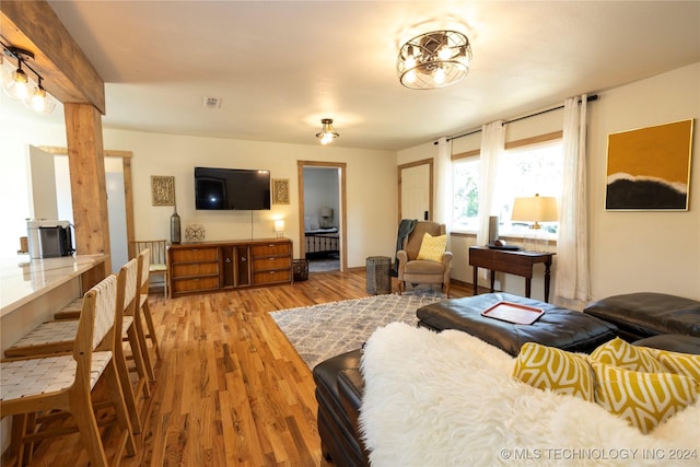 living area with visible vents and wood finished floors