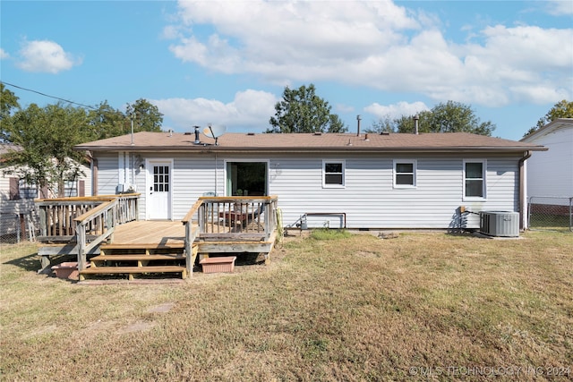 rear view of property featuring a lawn, a wooden deck, and central air condition unit