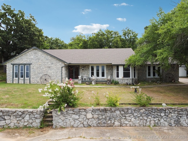 single story home featuring covered porch and a front yard