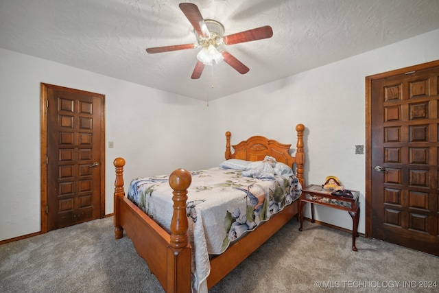 bedroom with ceiling fan, carpet floors, and a textured ceiling