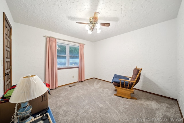 sitting room featuring carpet floors, a textured ceiling, and ceiling fan