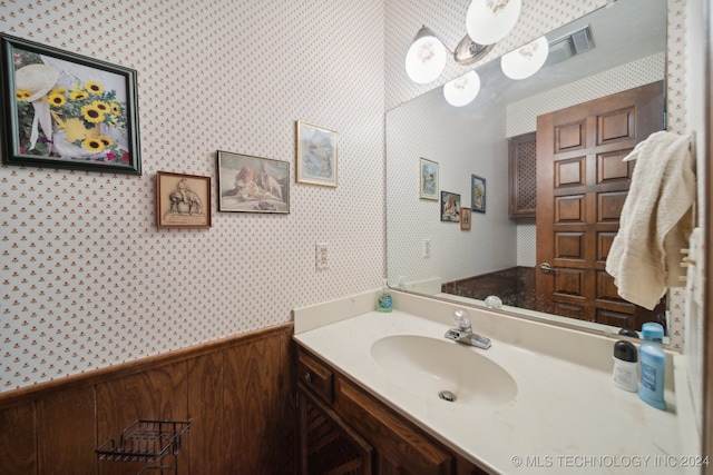 bathroom with wood walls and vanity