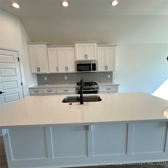 kitchen with sink, appliances with stainless steel finishes, white cabinets, and tasteful backsplash