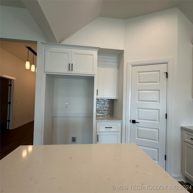 kitchen featuring white cabinetry, backsplash, lofted ceiling, and dark hardwood / wood-style flooring