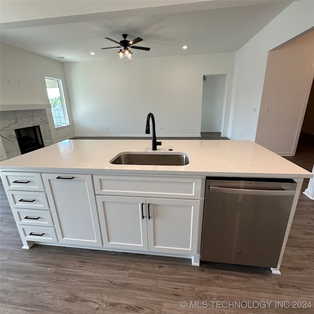 kitchen with a kitchen island with sink, sink, stainless steel dishwasher, and white cabinets