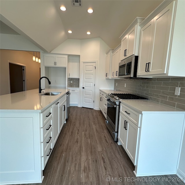 kitchen featuring tasteful backsplash, white cabinetry, dark hardwood / wood-style floors, sink, and stainless steel appliances