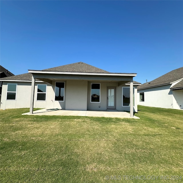 back of property featuring a patio area and a lawn