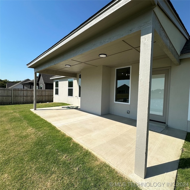 back of property featuring a yard and a patio area