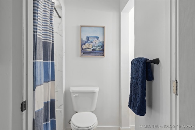 bathroom with a shower with curtain and toilet