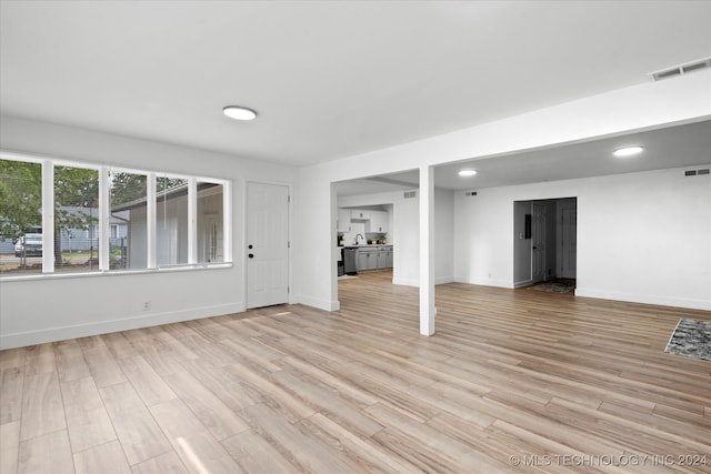 basement featuring sink and light hardwood / wood-style floors