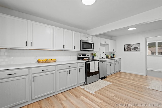 kitchen featuring light wood-type flooring, white cabinetry, appliances with stainless steel finishes, and sink