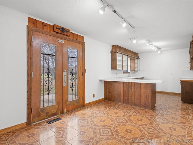 kitchen with kitchen peninsula, light tile patterned floors, and french doors