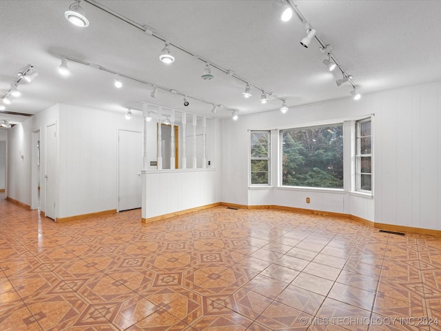 tiled spare room with a textured ceiling