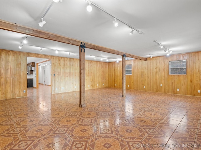 basement with tile patterned flooring and wooden walls