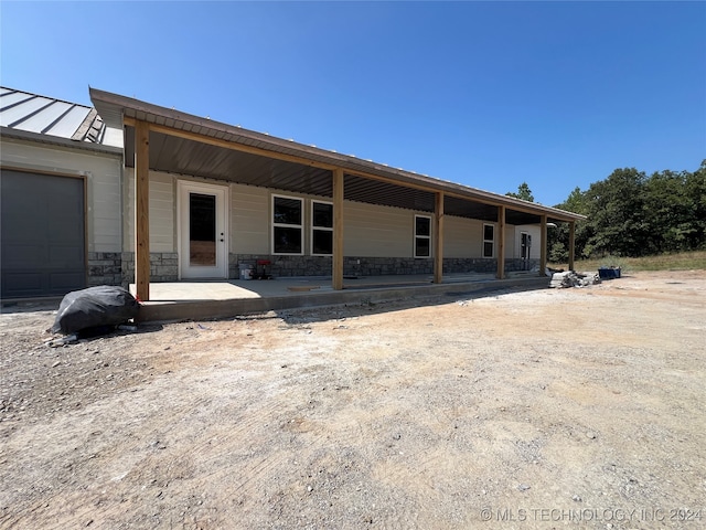 back of house with a garage and a porch