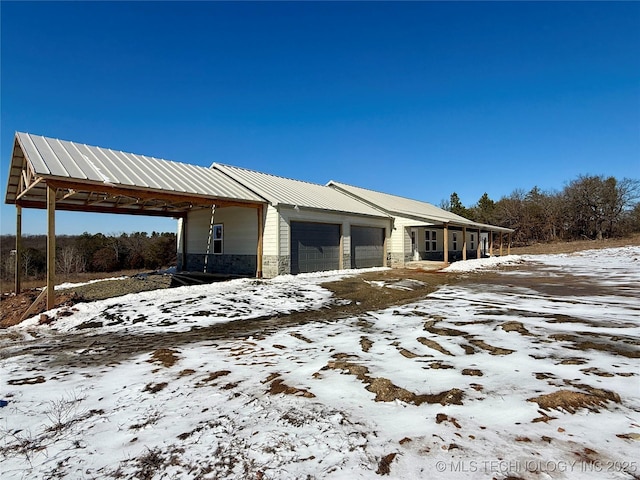 view of snow covered exterior featuring a garage