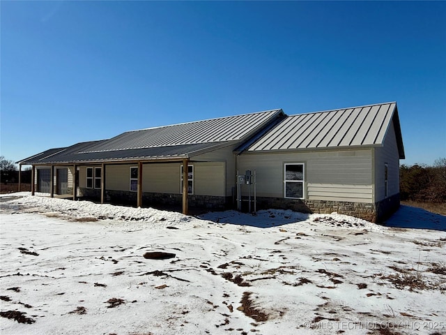 view of snow covered back of property