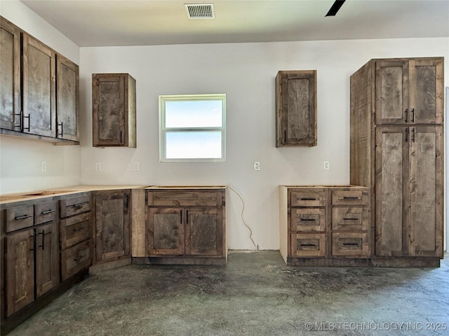 kitchen featuring ceiling fan and dark brown cabinetry