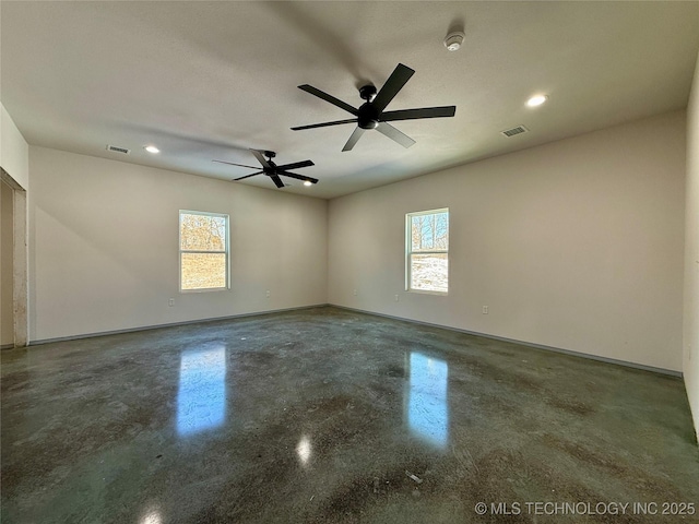 empty room with ceiling fan and a wealth of natural light