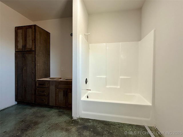 bathroom featuring concrete floors, tub / shower combination, and vanity