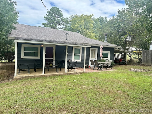 back of property with a patio area and a yard