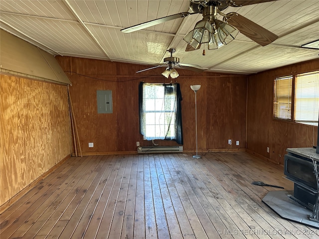 unfurnished room featuring light wood-type flooring, a wood stove, wood walls, and ceiling fan