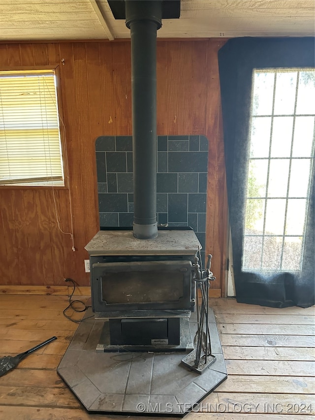 interior details with a wood stove, hardwood / wood-style floors, and wooden walls