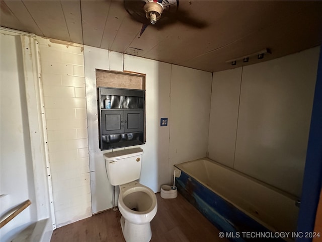 bathroom featuring a bathtub, toilet, and hardwood / wood-style flooring