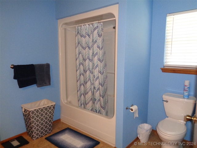 bathroom with shower / bath combo with shower curtain, toilet, and tile patterned floors