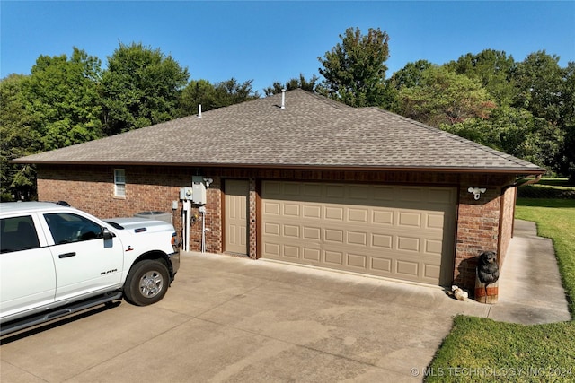 view of property exterior featuring driveway, brick siding, and roof with shingles