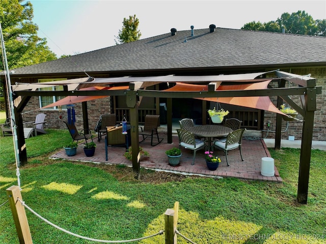 back of property featuring a shingled roof, a lawn, and a patio