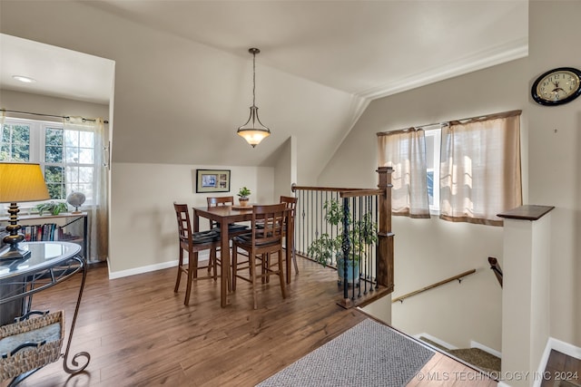 dining space with hardwood / wood-style floors and vaulted ceiling