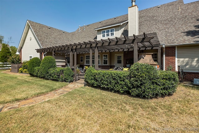 rear view of house with a pergola and a yard