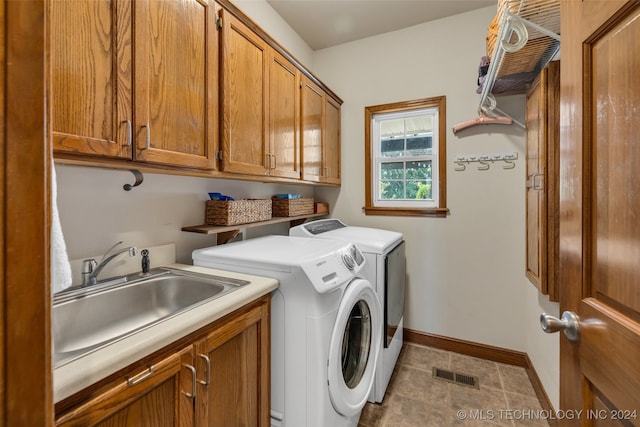 laundry room featuring tile patterned flooring, cabinets, separate washer and dryer, and sink