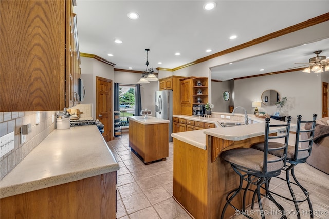 kitchen featuring tasteful backsplash, kitchen peninsula, sink, a kitchen island, and hanging light fixtures