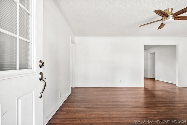 unfurnished room featuring a textured ceiling, ceiling fan, and dark hardwood / wood-style floors