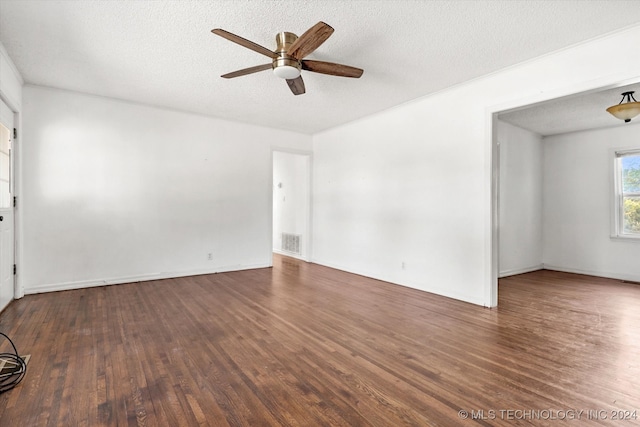 empty room featuring a textured ceiling, ceiling fan, and dark hardwood / wood-style floors