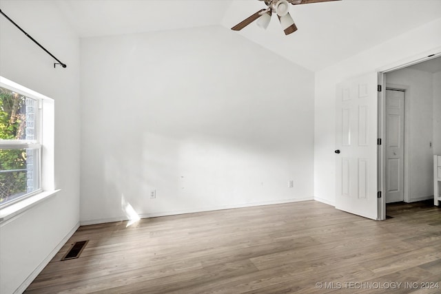 unfurnished room featuring lofted ceiling, hardwood / wood-style floors, and ceiling fan