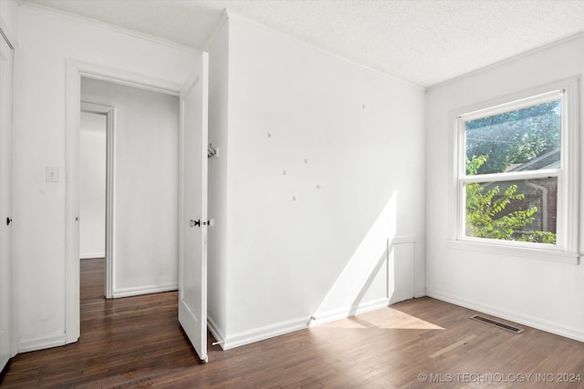 empty room featuring dark wood-type flooring and a textured ceiling