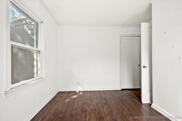 unfurnished room featuring dark hardwood / wood-style floors and crown molding