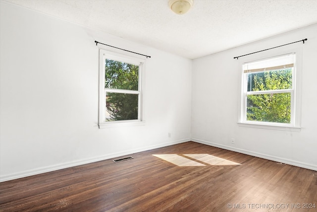 spare room featuring a textured ceiling and hardwood / wood-style floors