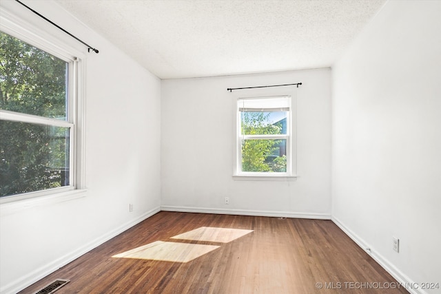 spare room featuring a textured ceiling and hardwood / wood-style flooring