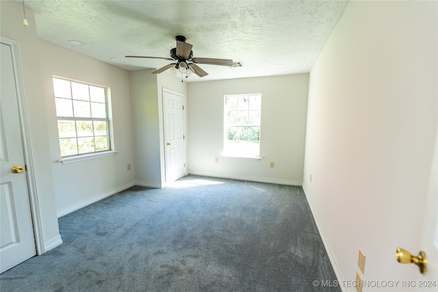 unfurnished bedroom with ceiling fan, carpet, and a textured ceiling