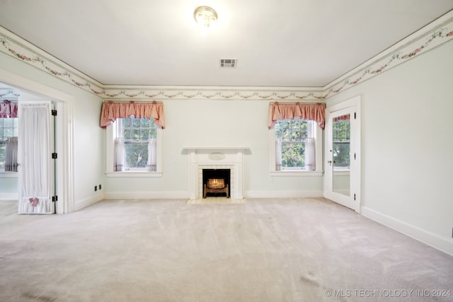 unfurnished living room featuring carpet, a fireplace, and crown molding