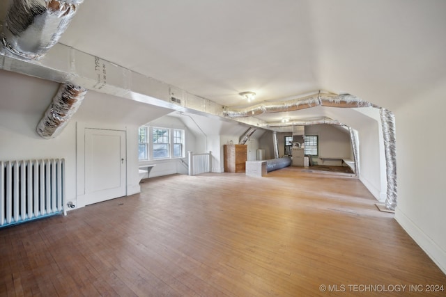 unfurnished living room featuring radiator and hardwood / wood-style flooring