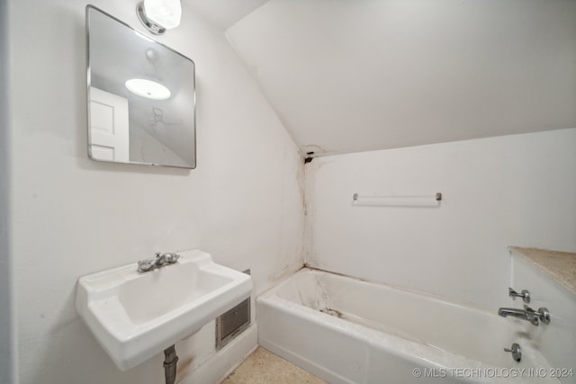 bathroom with shower / tub combination, lofted ceiling, and sink