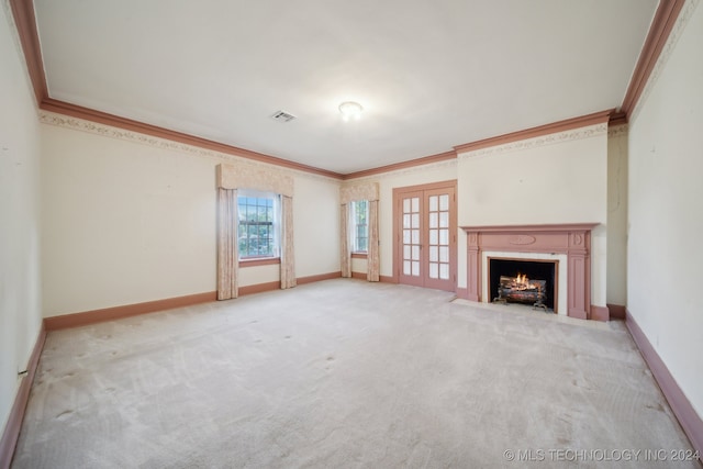 unfurnished living room featuring ornamental molding, light carpet, and french doors