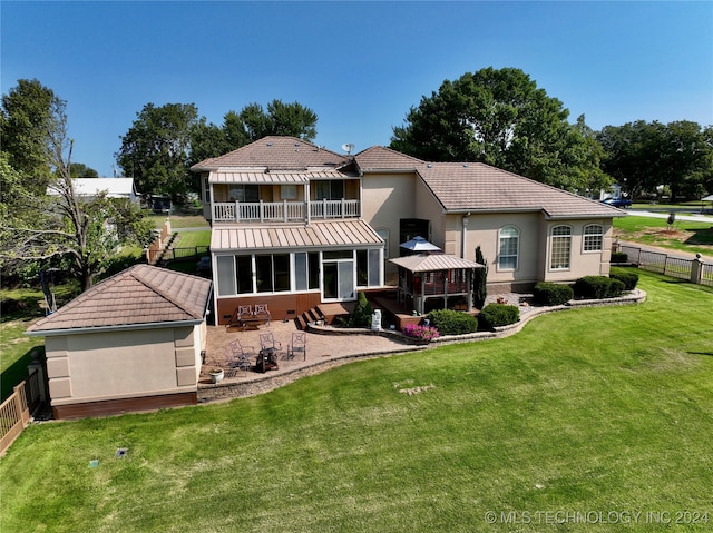 back of house featuring a balcony, a gazebo, a yard, and a patio area